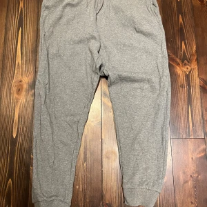 Grå mjukisbyxor från Selected Homme - Grå mjukisbyxor från Selected Homme med elastisk midja och dragsko. Byxorna har ribbade muddar vid bensluten, en bakficka och mjukt material i bomullsblandning. Storlek XL. För små för mig är 193 brukar ha XL. Skulle säga att dem är L. M om man vill ha lite baggy. Nypris 700. Aldrig använda då dem är för små.