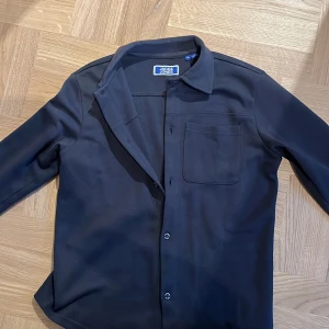 Overshirt  - En blå overshirt från Jack and Jones, stl 152. Riktigt snygg skjorta som passar till väldigt många olika situationer. 