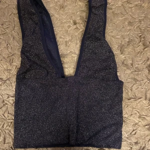 Glittrig mörkblå croppad topp BDG - Säljer en glittrig mörkblå croppad topp från BDG Urban Outfitters. Toppen har djup v-ringning och är ärmlös med breda axelband. Perfekt för att sticka ut med sitt glittriga material och trendiga look. Pris diskuteras vid snabb affär 💕💕