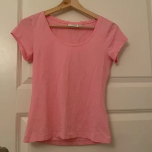 Rosa kortärmad topp från Kappahl - Söt rosa topp från Kappahl i storlek XS. Modellen är enkel med rund halsringning och korta ärmar. Tillverkad i mjuk bomull som känns skön mot huden. Perfekt att matcha med jeans eller kjol för en fräsch look. Använd 1-2 gånger.