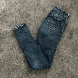 Replay Jeans - Snygga blå Replay jeans med slim passform och klassiska bakfickor med dekorativ söm. Jeansen har en normal midja och är tillverkade i ett mjukt denimtyg som sitter skönt längs benen. Perfekta för dig som gillar en stilren och enkel look.