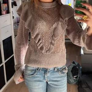 Grå stickad tröja  - Supersöt grå stickad tröja med volangdetaljer över axlar och bröst💕 Jätteskönt material och nästan som ny💕 