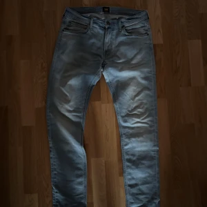 Ljusblå Lee Luke jeans W32 L34 - Säljer ett par ljusblå Lee Luke jeans med klassisk femficksdesign och snyggt detaljer. Jeansen har normal passform och raka ben, tillverkade i mjukt bomullstyg med lite stretch för extra komfort. Har inga defekter. 