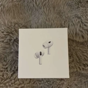 AirPods Pro - Apple AirPods Pro i originalförpackning, komplett med laddningsetui och kabel. Produkten ser ut att vara i mycket gott skick utan synliga repor eller slitage. Perfekt för trådlös musik och samtal med aktiv brusreducering och hög ljudkvalitet. Aldrig använt fick fel i present pris kan diskuteras