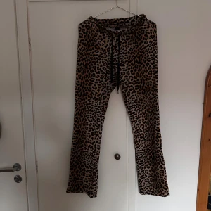 Leopardmönstrade byxor från Gina Tricot - Leopardmönstrade mjukis byxor från Gina Tricot med bootcut och snörning i midjan. Byxorna är i mjuk polyesterblandning med elastan för extra stretch och komfort. Välanvända men fortfarande bra skick 
