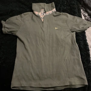 Burberry piké  - Säljer denna äkta burberry piken då den är för stor den är snygg och perfekt till sommarn den har ett litet hål i armen 