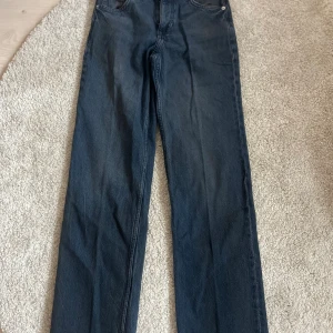 Straight jeans blå  - Snygga mörkblå jeans med klassisk femficksdesign och raka ben. Jeansen har inte så hög midja , dragkedja och knappstängning framtill. Perfekt för dig som gillar en tidlös och clean look. Materialet är slitstarkt denim i bomull.