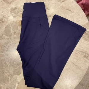 Lululemon flare tights marinblå - Marinblå tights som är utsvängda i superfint skick, som nya. Innerbenslängd 76cm, säljer även matchande define jacket💙