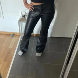 Lågmidjade skinnbyxor - Snygga svarta bikbok byxor i skinnimitation med raka ben. Lågmidjade i storlek 36. Aldrig kommit till användning. Nypris 600kr