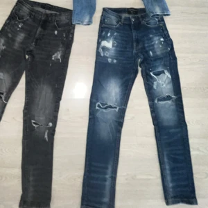 Supply & Demand slitna jeans -  jeans från Supply & Demand, ett par i mörkblå. har slitna detaljer och hål på benen för en riktigt edgy look. Klassisk femficksmodell med raka ben och snygga tvättade effekter. Perfekta för dig som gillar streetstyle.