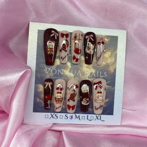 ChocoBear (M);Long Coffin - Handgjorda press-on naglar i långa ballerinaform, dekorerade med gulliga björnar, choklad, körsbär och rosetter i rött, brunt och beige. Mix av glittriga vinröda och nude baser med detaljer som texten 'sweet', 'love' och 'lucky'. Perfekt för dig som vill ha unika och lekfulla naglar. I storlek M: 16 mm, 12 mm, 12,5 mm, 11,5 mm, 10 mm