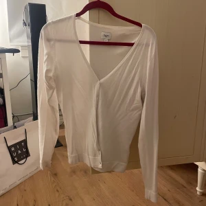 Kofta med v-rigning och knappar - Använd 2-3 gånger