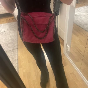 Rosa axelväska från borse in pelle  - Cool rosa axelväska från borse in pelle med kedjedetaljer i metall och snygga sömmar längs kanterna. Väskan är gjord i äkta skinn tillverkad i Italien köpt i Grekland för 1300kr 