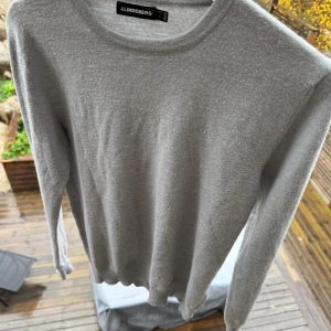 Grå stickad tröja från J.Lindeberg - Snygg grå stickad tröja från J.Lindeberg i storlek S-xs beroende på om ni vill ha tajt passform eller baggy . Tröjan har rund halsringning, diskret logga på bröstet och långa ärmar. Perfekt för dig som gillar stilrena och klassiska plagg med en modern touch.