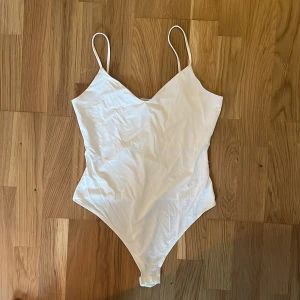 Vit body - Vit body från HM i väldigt gott skick! Stretchigt material med reglerande-band.