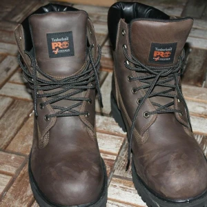 Timberland PRO bruna boots herr USA exclusive (Helt Nya) - Timberland PRO boots i mörkbrunt skinn med svart vadderad krage och grov platt sula. Klassisk snörning med metallöglor och robust design, perfekt för dig som gillar street och outdoor. Märkt med ReBOTL och PRO-logga på plösen.  Kvitto kartong och bevis finns