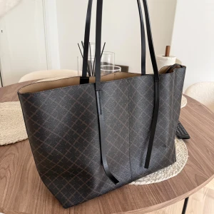 By Malene Birger väska - Stilren svart shoppingväska från By Malene Birger med rutigt mönster och långa svarta handtag. Väskan är rymlig med beige insida och har en matchande innerficka. Väskan är i fint skick. Handtagen är trasiga men går säkert att byta ut ifall man vill de 💓