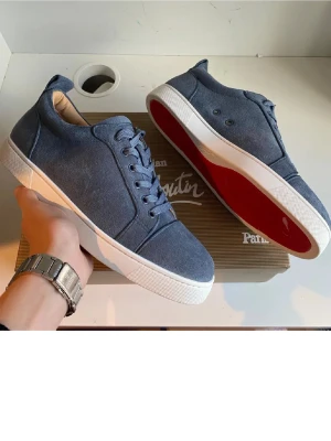 Blå Christian Louboutin sneakers - Säljer dessa blå sneakers storlek 43 från Christian Louboutin med klassisk röd sula och vit kant. Skorns är helt nya och aldrig använda. Skorna har rund tå, snörning och är tillverkade i mocka med en stilren design. Pris kan diskuteras!