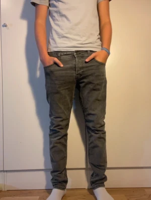 Grå skinny jeans från Jack & Jones - Säljer ett par gråa skinny jeans från Jack & Jones i modellen slim/glenn. Jeansen har lite stretch för extra komfort. Stilrena och passar till nästan allt.