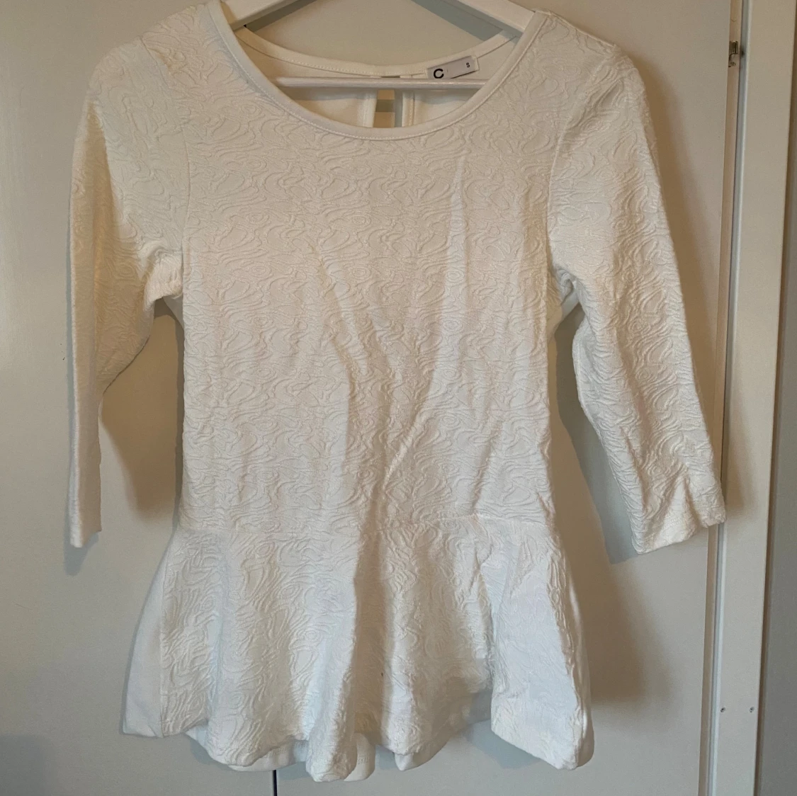 Vit peplumtop med strukturmönster