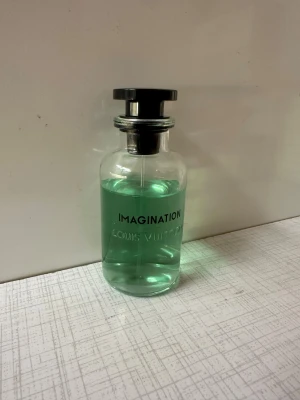 Louis Vuitton Imagination parfym - Stilren parfym från Louis Vuitton med modern design. Perfekt för dig som vill sticka ut med en exklusiv touch. Flaskans gröna färg ger en fräsch känsla. Passar dig som gillar lyxiga detaljer. Den har legat på vinden uppe i lite mer en ett år nu och kartongen har jag tappat bort. Kan leta lite mer om det önskas.