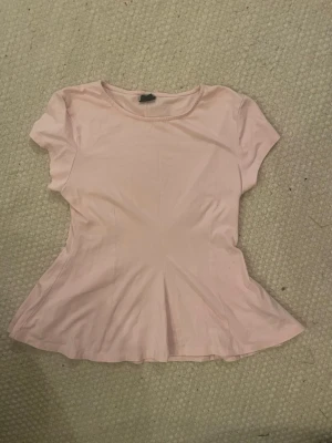 Utsvängd topp - En rosa topp som är utsvängd vid magen 