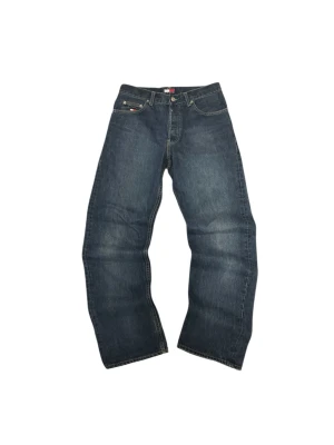 Tommy Hilfige jeans  - Snygga blå jeans från Tommy Hilfiger med klassisk straight fit och normal passform. Jeansen har fem fickor, gul kontrastsöm och ikonisk Tommy Hilfiger-logga på fickan och bak vid midjan. Tillverkade i slitstarkt denimmaterial.