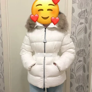 Vit Moncler dunjacka med päls - Säljer en vit dunjacka från Moncler med fluffig päls på huvan och snyggt bälte i midjan.  Varm och skön! Ny men passade inte mig