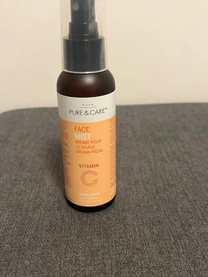 Pure & Care Face Mist Vitamin C - Face mist med vitamin C som ger extra fukt och fräsch känsla till huden. Kommer i en brun plastflaska med sprayfunktion och orange etikett. Innehåller ingredienser som aloe vera, havreextrakt och cloudberry. Perfekt för att boosta huden med lyster och återfuktning.