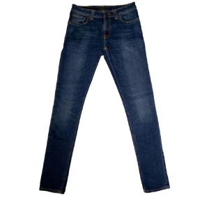 Mörkblå jeans från Nudie - Snygga mörkblå skinny jeans från Nudie med klassisk femficksdesign och kontrastsömmar. Jeansen har en smal passform och är tillverkade i stretchigt denim för extra komfort. Perfekta för dig som gillar en stilren och modern look. Hör av dig för frågor eller om di är intresserad.