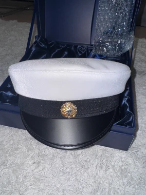 Studentmössa C.L. Seifert 57.5 - Helt ny och oanvänd studentmössa från C.L. Seifert. Jag säljer mössan pga en felbeställning min pojkvän gjorde 🙈 Den är en gala mössa med princess kokard i guld utan någon text fram eller bak. Perfekt om man vill brodera själv för en billigare peng🥰den är i storlek 57.5, man kan kolla upp sin storlek på deras hemsida! Kan diskutera pris. Ny pris-1299 obs: boxen ingår inte