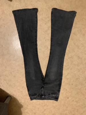 Svarta bootcut jeans med hög midja - Säljer ett par svarta jeans med bootcut-snitt och hög midja. Jeansen har klassisk femficksdesign och är tillverkade i ett slitstarkt jeansmaterial. Snygga att matcha med sneakers eller boots för en cool look.