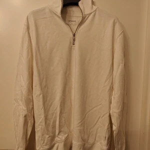 Vit half zip tröja från Lindbergh - Vit långärmad tröja från Lindbergh med half zip-dragkedja i halsen. Enkel och clean design utan mönster, tillverkad i mjuk bomull. Perfekt för dig som gillar stilrena och bekväma plagg med lite sportig vibe.