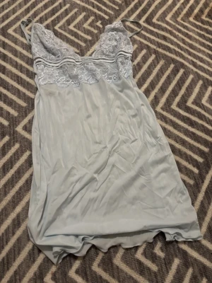 Långt ljusblått linne - Fint långt linne gjord av spets vid bysten. Med annat material på den nedre delen av linnet. Märket eller storleken nämns inte, men passar mig som är S!