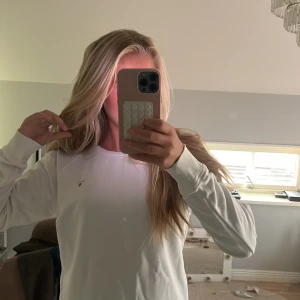 Vit långärmad tröja från Gant - Säljer en stilren vit långärmad tröja från Gant med liten logga på bröstet. Tröjan har en klassisk passform och är gjord i mjuk bomull, perfekt för en clean och enkel look.