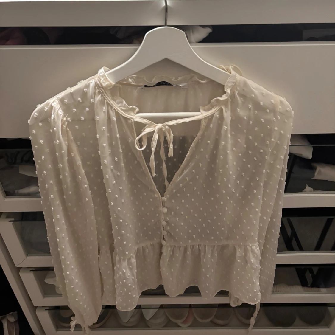 Vit blus med knyt och volang