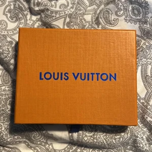 Louis Vuitton ask  - Snygg ask från Louis Vuitton med blå logga på locket. Perfekt för att förvara accessoarer eller små väskor. Klassisk och lyxig design. 