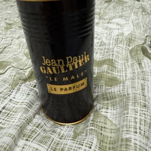 Jean Paul Gaultier Le Male Le Parfum - Jean Paul Gaultier Le Male Le Parfum i en ikonisk svart flaska formad som en manlig torso med gulddetaljer. Kommer i en lyxig svart och guld metallburk, 125 ml. En maskulin och modern doft med elegant design som sticker ut på hyllan.