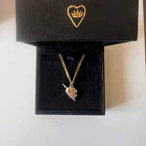 Guldigt halsband Maria Nilsdotter - You & Me i guld med ordinarie förpackning. Halsband ifrån Maria Nilsdotter, äkta. Använd fåtal gånger men säljer då jag har köpt ett silvrigt. Ordinarie pris 2500 men säljer för 1900kr då hjärtat har börjat tappat lite färg.