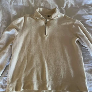 Beige half-zip tröja - Säljer en snygg beige half-zip tröja i mycket fint skick. Perfekt för både vardag och lite mer uppklädda tillfällen.