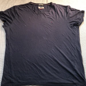 Mörkblå t-shirt från Tommy Jeans - Snygg mörkblå t-shirt från Tommy Jeans med klassisk rund hals och liten broderad logga på bröstet. Regular fit och tillverkad i mjuk bomull. Perfekt för dig som gillar enkel och stilren design med en touch av street.