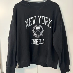 Svart sweatshirt New York Tribeca H&M - Svart sweatshirt från H&M med tryck 'New York Tribeca' i storlek L men jag som XS har även använt den. Säljes för 100kr
