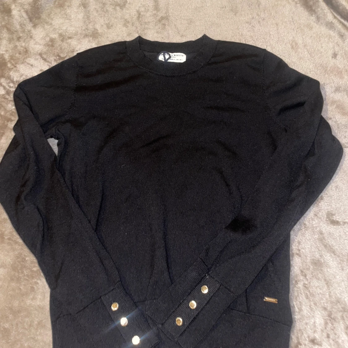 Svart stickad tröja med guldknappar