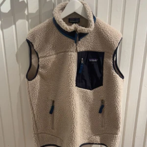 Beige fleeceväst från Patagonia - Säljer en beige fleeceväst från Patagonia. Inga fel på västen utan i väldigt gott skick! Säljes pga fel storlek!