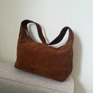 Brun mocka axelväska från NA-KD - Brun mocka väska från NAKD helt oanvänd! Nypris 900kr. Pris kan diskuteras vid snabbt köp!☺️