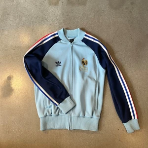 Vintage adidas tröja - Tvärfet adidas tröja med Frankrike vibe me tuppen o deras tre färger på ärmarna. Aldrig sett denna tidigare men tyvärr lite för liten för mig. Köp sker via ”köp nu” funktionen :) 