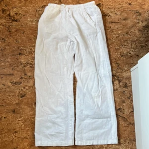 Vita linnebyxor från H&M, stl 140 - Snygga och luftiga vita linnebyxor från H&M i storlek 140. Byxorna har resår i midjan och raka, vida ben för en chill och avslappnad look. Perfekta för varma dagar när du vill ha något bekvämt och stilrent.