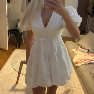 Vit kort klänning broderier textur v-ringning puffärm - Jättefin puffig klänning från Eva Jansson i storlek S. Den är aldrig använd på grund av att den inte passade mig💕