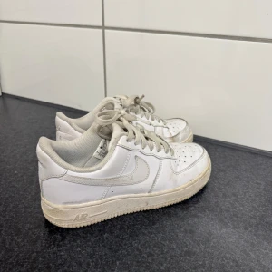 Vita Nike Air Force 1 sneakers - Klassiska vita Nike Air Force 1 sneakers i skinn med perforerad tå, snörning och låg profil.( Går att tvätta dom)