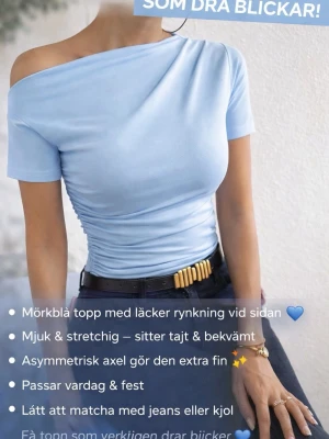 Ljusblå oneshoulder topp med rynkning - Säljer en ljusblå topp med asymmetrisk axel och snygg rynkning på sidan. Toppen är oneshoulder, har kort ärm och är gjord i ett mjukt, stretchigt material som sitter tight. Perfekt att styla med jeans eller kjol för en trendig look.